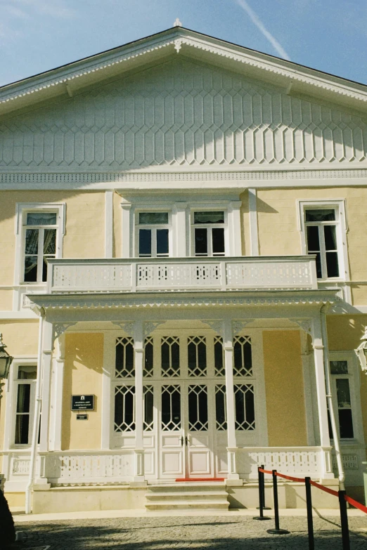 a yellow and white building with a red stop sign in front