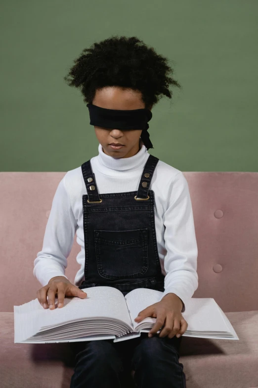 a young person sitting on top of a couch wearing an blind folded eye patch