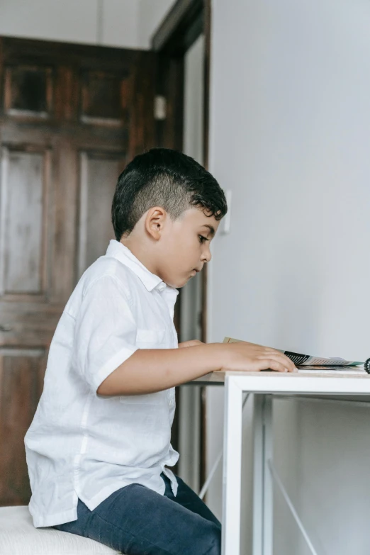 a  sitting down at a white desk typing