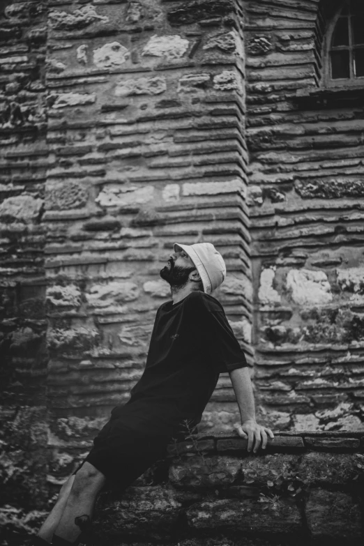 black and white po of a man sitting on a ledge