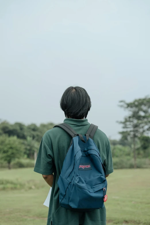 a person in a field looking into a sky with trees in the background