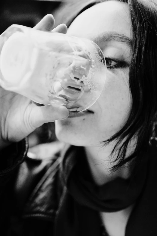 a woman drinking a bottle from a glass