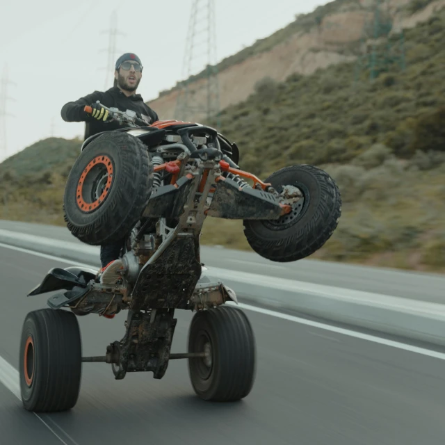 a man riding a large, four - wheeled vehicle in the middle of the street