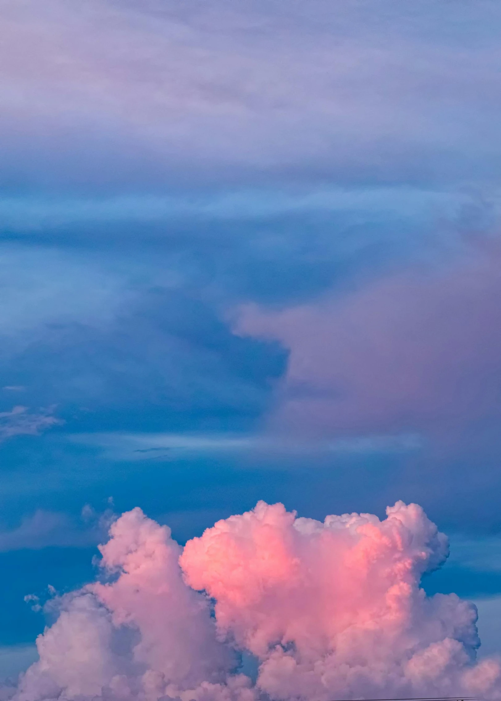 a jet in the sky with clouds near a mountain