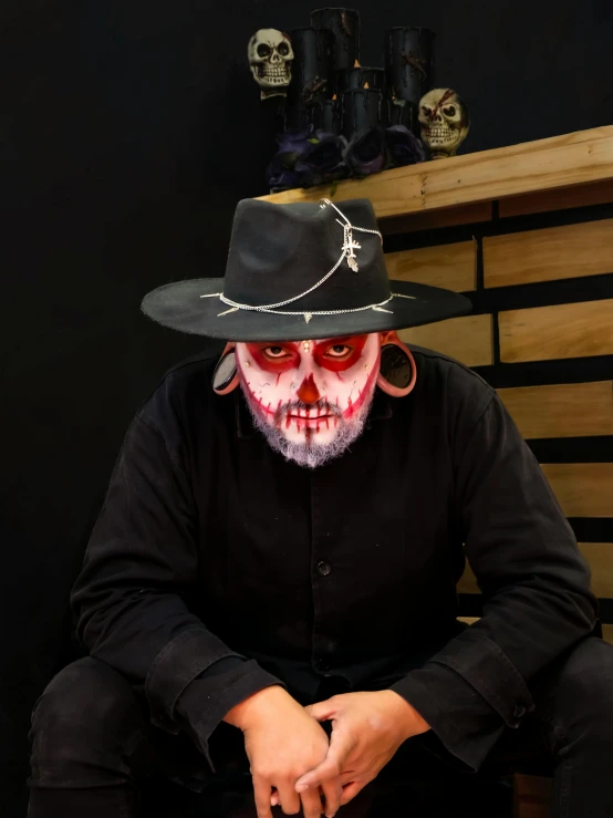 man with mask and hat sitting on a bench