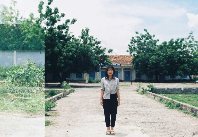 woman standing in front of a house and another person in the back