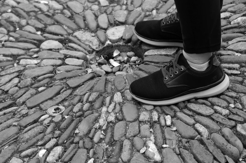 a person is walking on cobblestone walkway