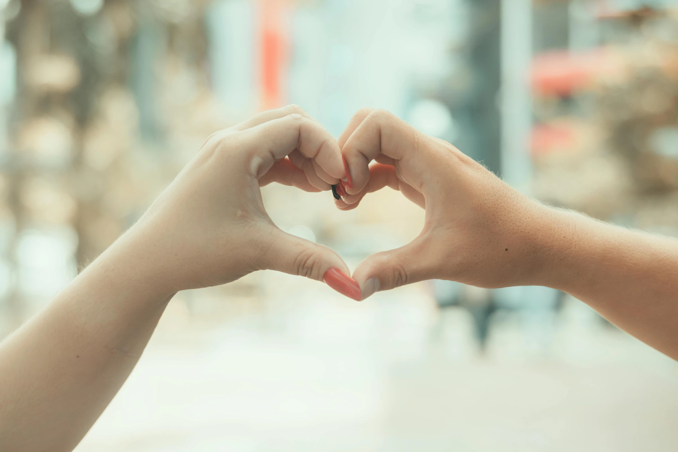 two hands hold the heart shape with their fingers