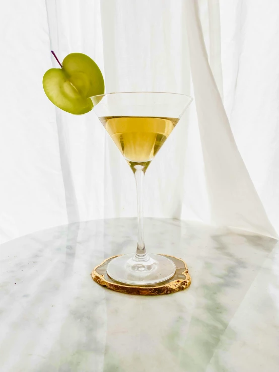 a glass with an olive on it on a table