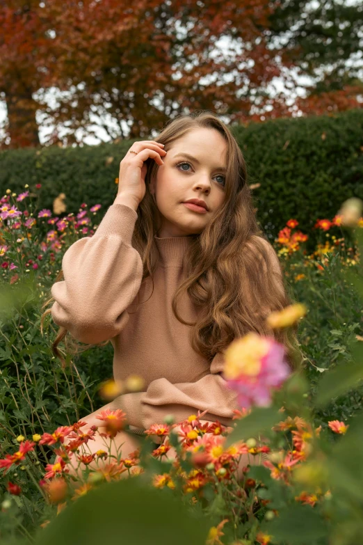 a child sitting in flowers and posing for a po