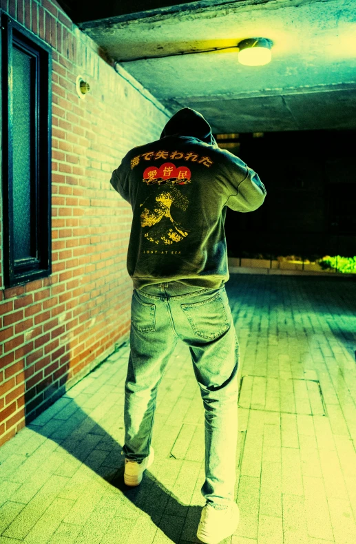 a man standing near a brick wall in a room