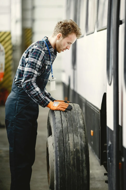 a man stands next to a tire in an automobile garage