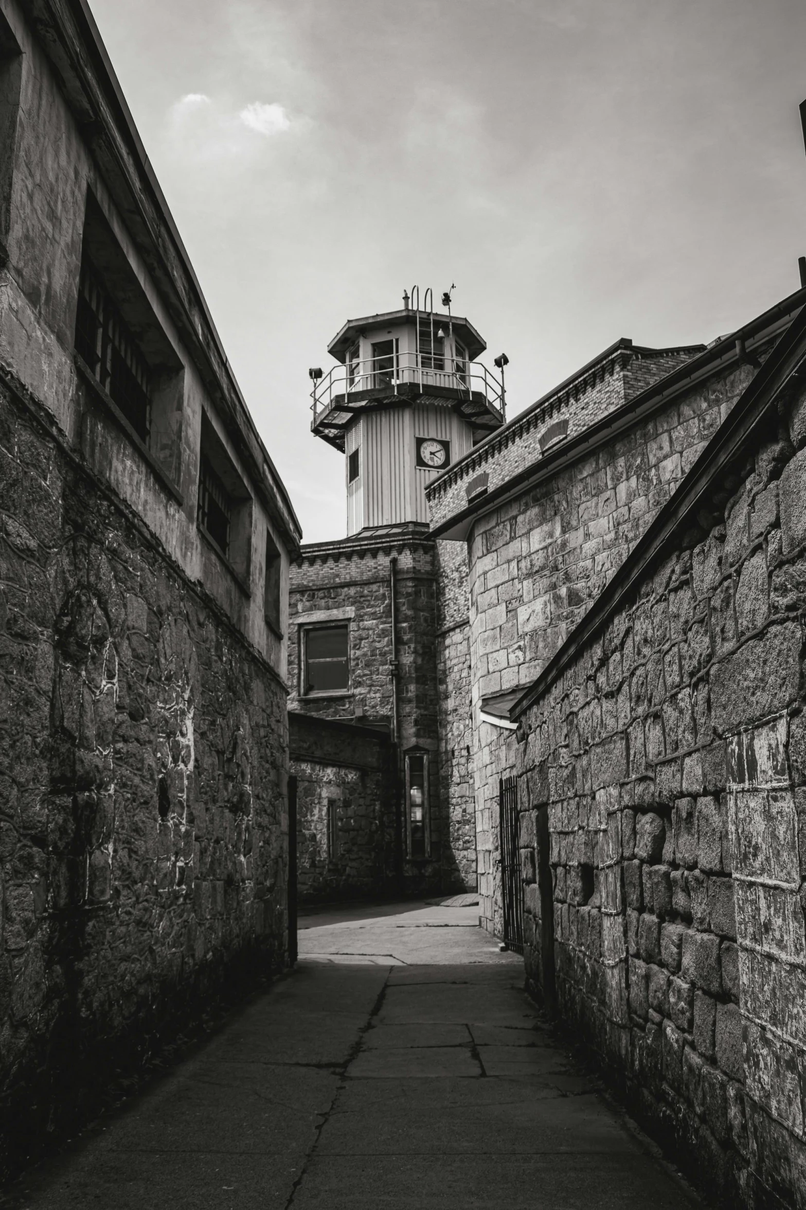 the alley is made out of cement walls and is in front of a light tower