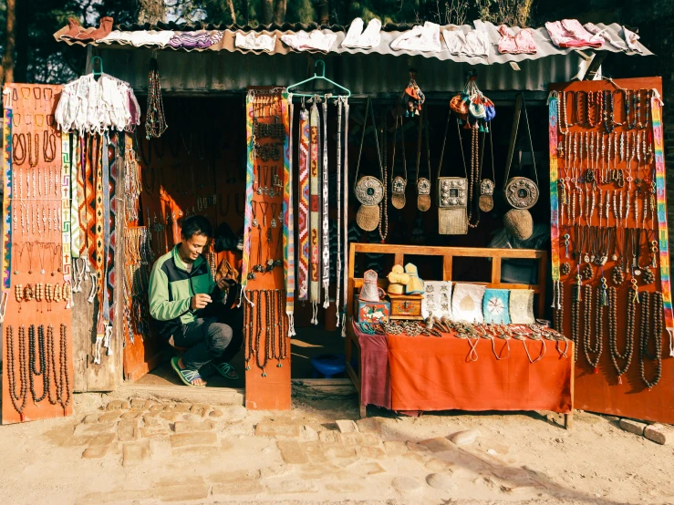 a small man selling beadwork and other beads on the roadside