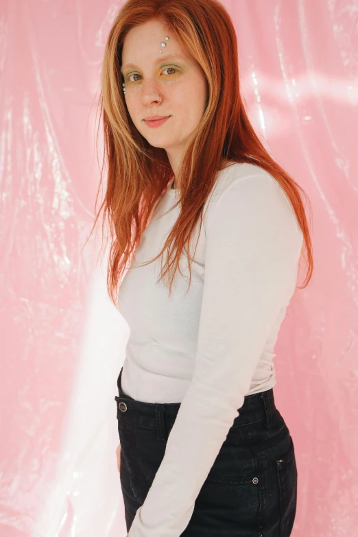 a young woman posing for a portrait in front of pink background