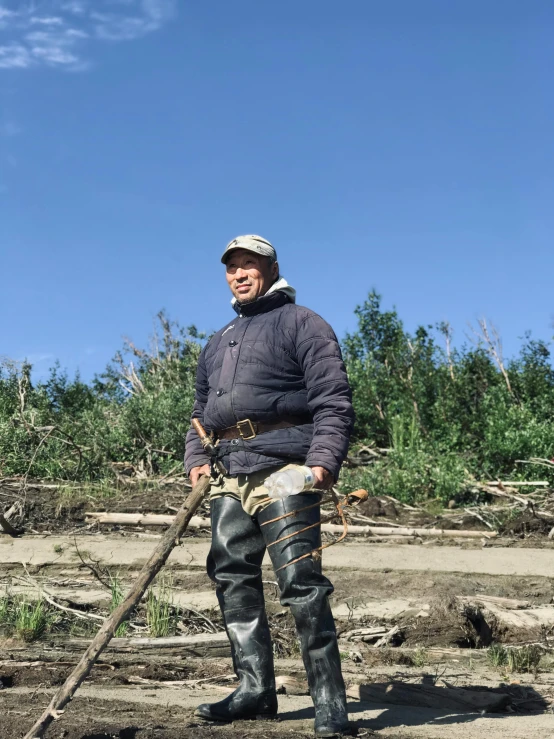 man in black jacket and pants with a stick