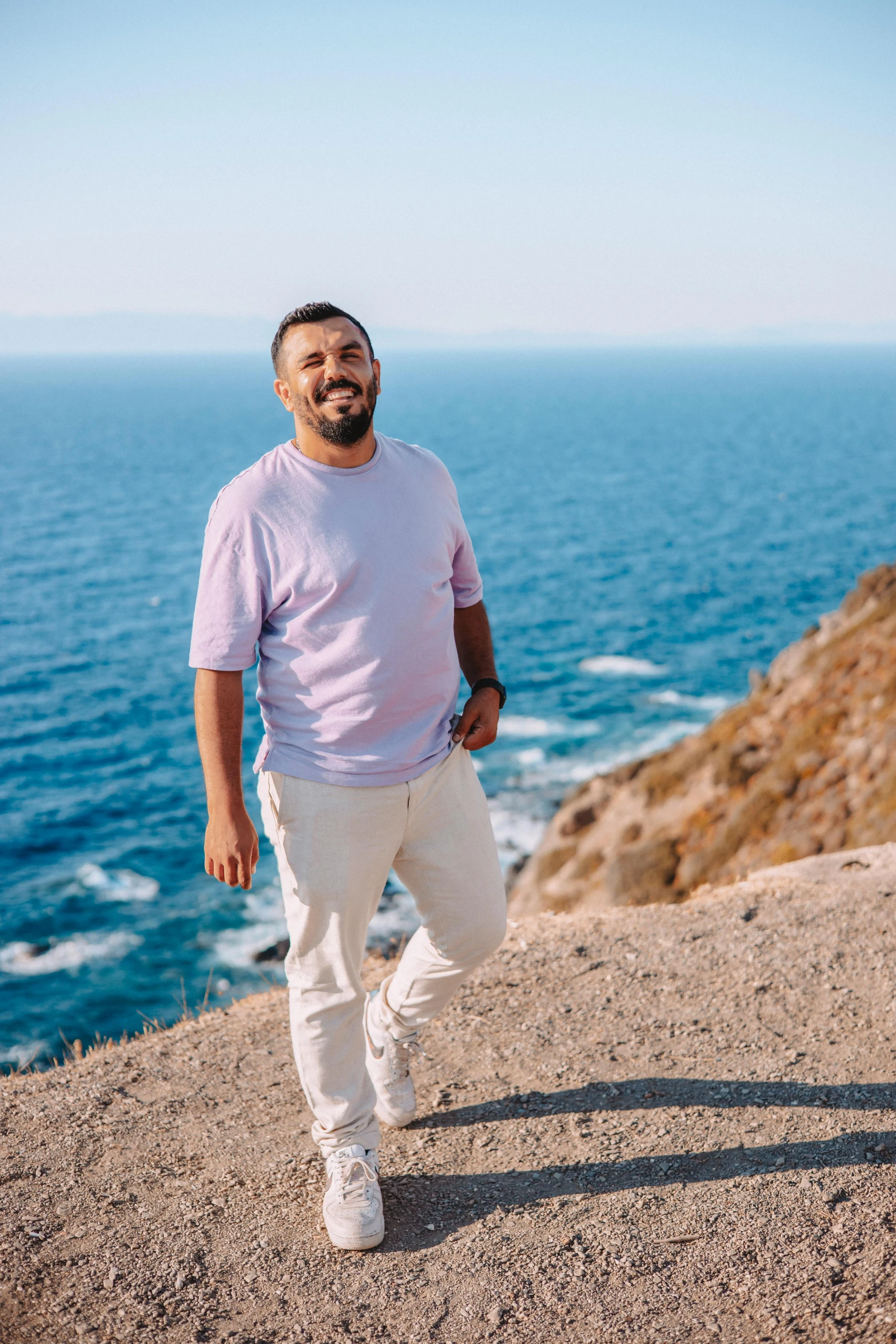 the man is enjoying some time out on the cliff by the ocean