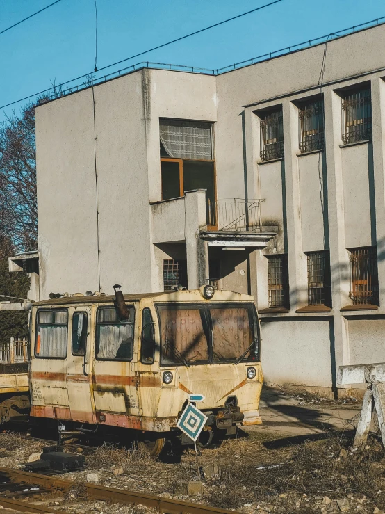 a rusted up bus and some buildings