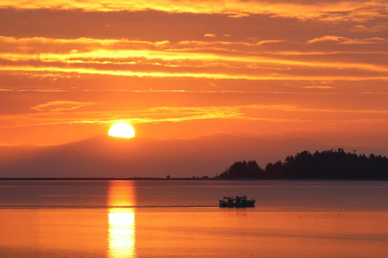 two boats are in the water at sunset