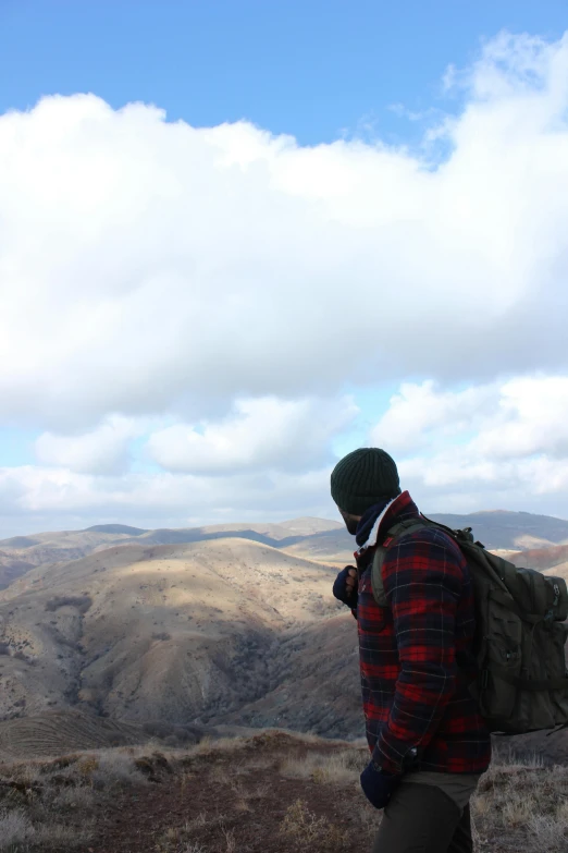 a person standing on top of a mountain holding a cell phone