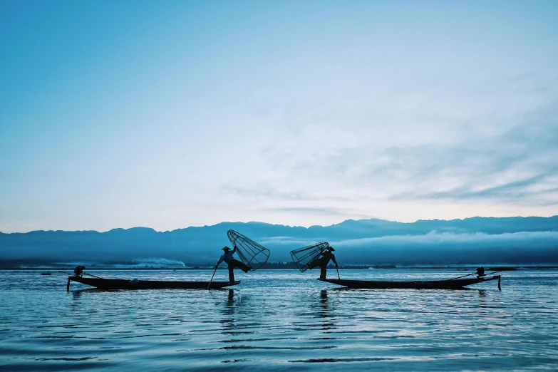 two men are in small boats near the shore