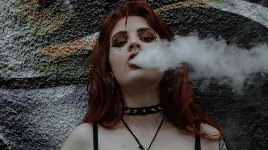 a woman smoking a cigarette on a brick wall