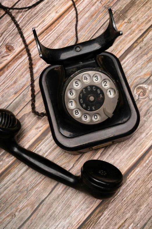 an old fashioned telephone sitting on a wooden table