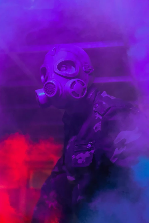 a man in gas mask with purple smoke in his face