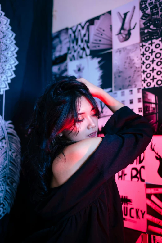 a woman holding her head in her hands standing by wall