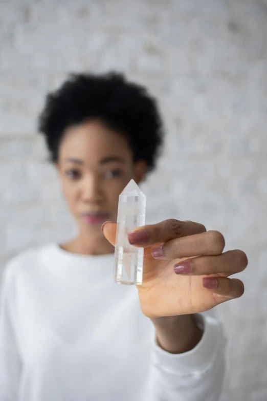 a woman is holding a small object and making a hand gesture