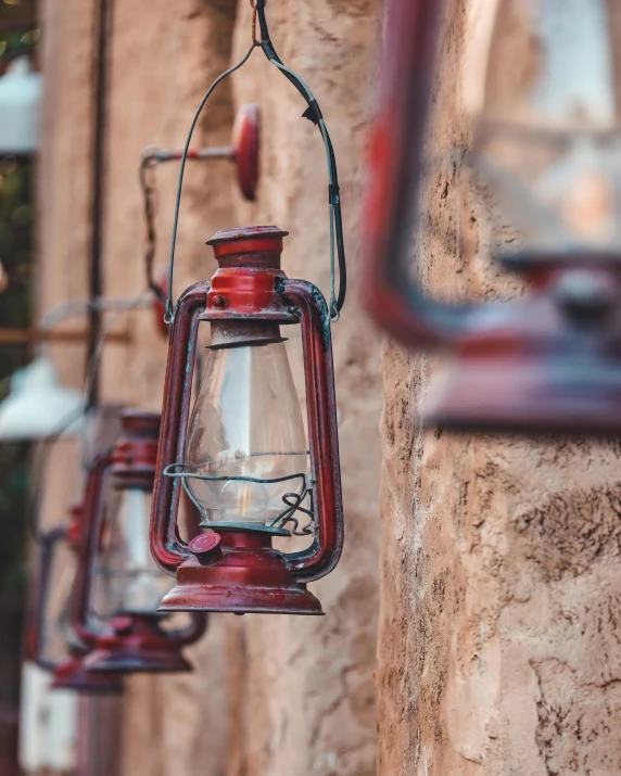 old red and clear lanterns hanging from stone wall