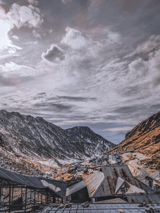 a large mountain area that has a cloudy sky above it