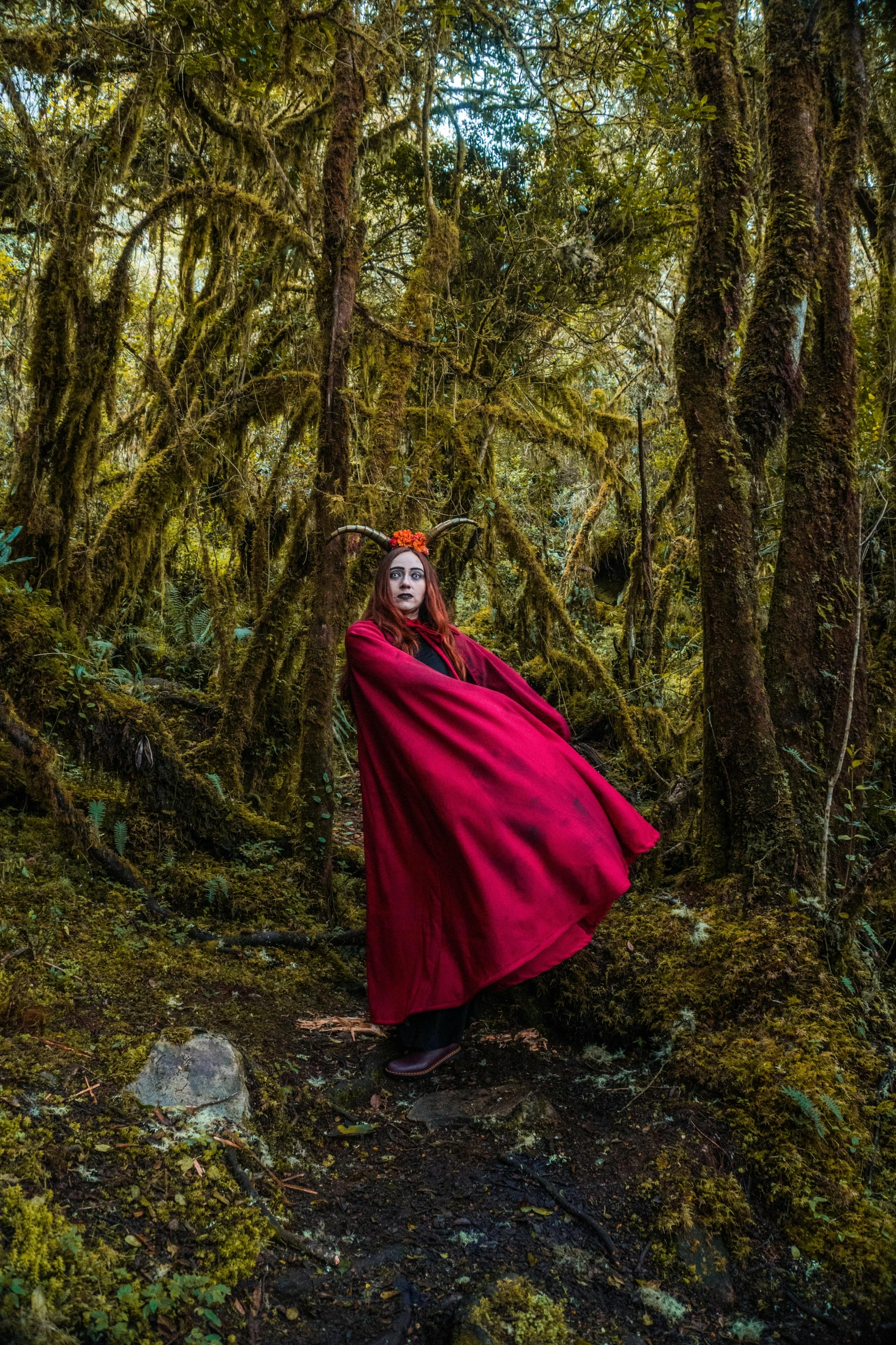 a woman dressed as a princess standing in the forest