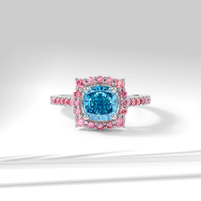 a blue and pink ring sits on a table