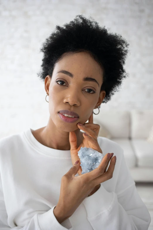 a young african american woman wearing pearls with a piece of silver jewelry around her neck