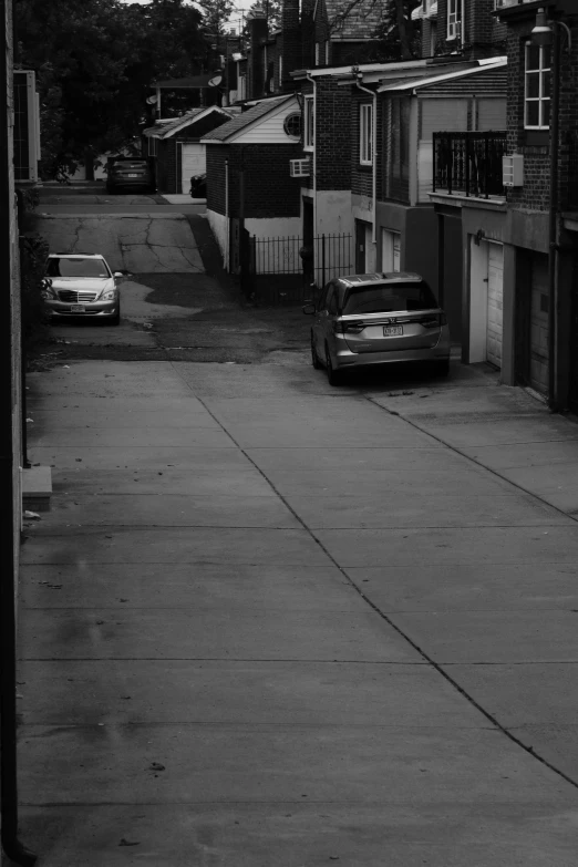 a large car sits parked on the road between small buildings