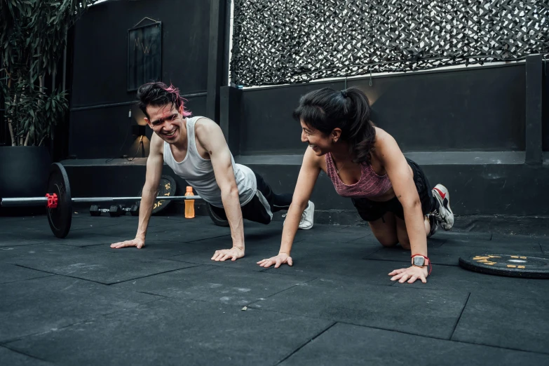 two people plank in a crossfit exercise with one holding a dumb