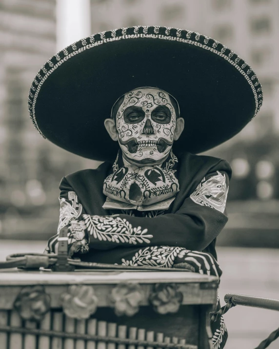 the skeleton in a sombrero is sitting on a cart
