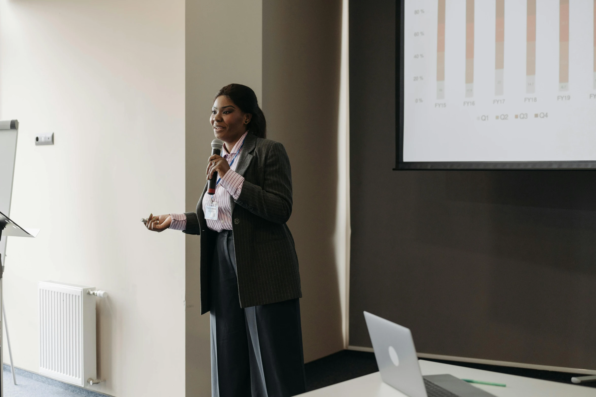 a woman holding a microphone giving a presentation