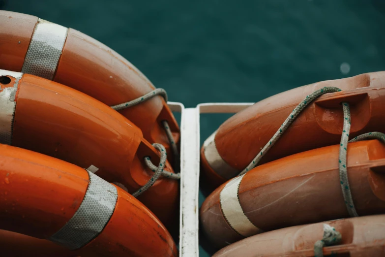 orange life savers tied to a dock in a harbor