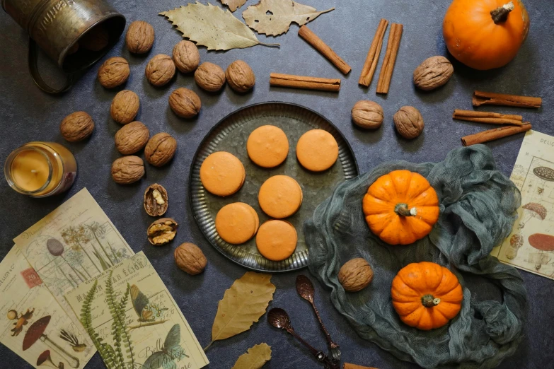 small orange cookies arranged around an assortment of fall decorations