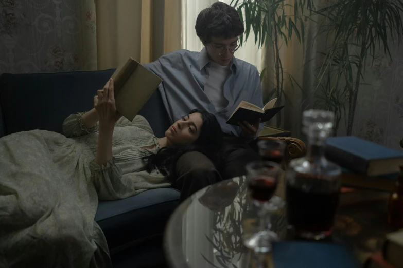 a woman laying on top of a bed next to a man holding an open book
