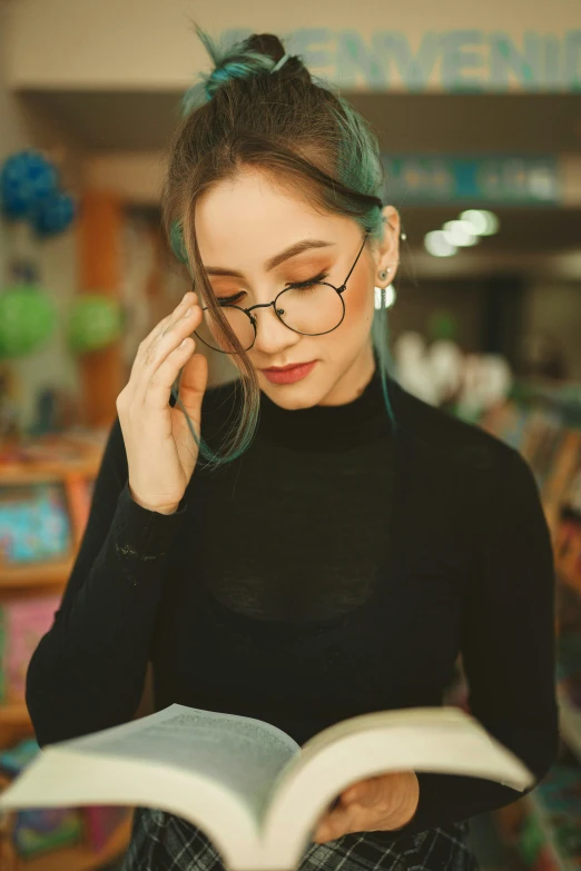 a young woman holding a book in her hand