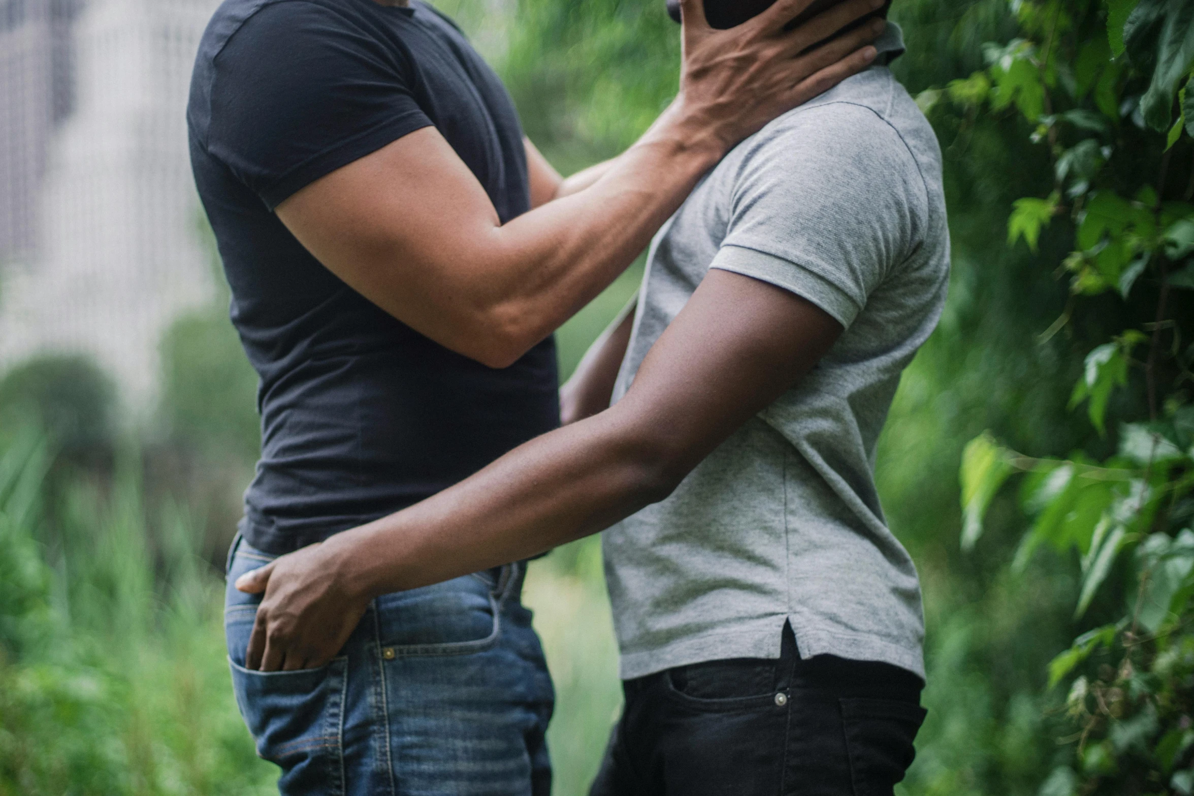 two people stand and talk on their cell phones