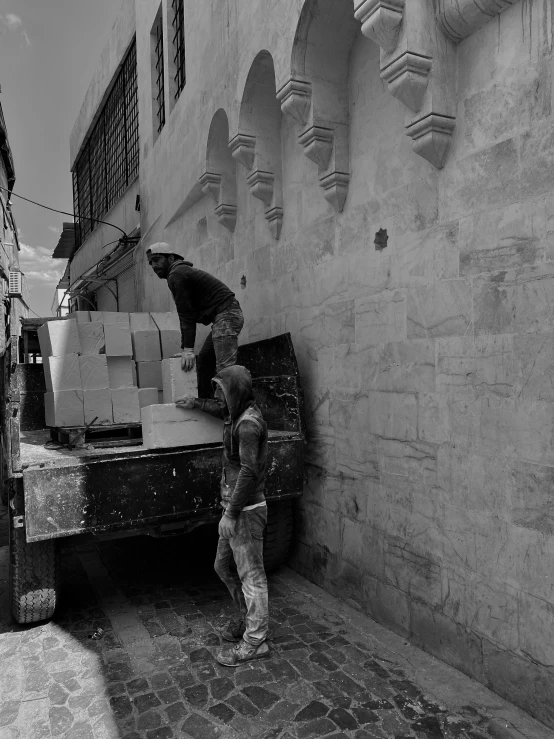 a man standing in front of a truck loaded with boxes