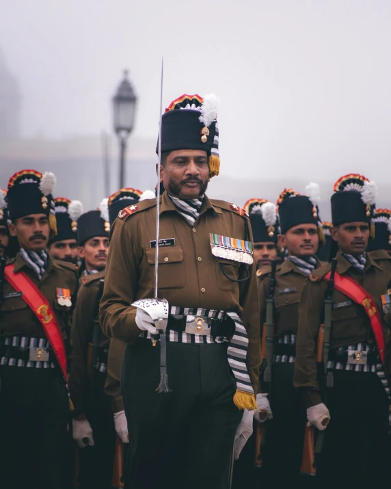 a man in military dress with other men in uniform