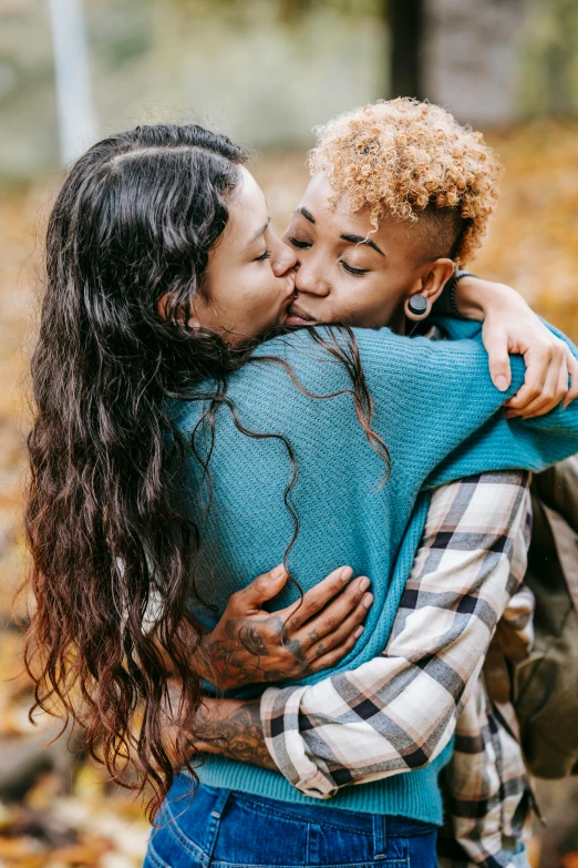 a mother hugs her son as they hug outside in the fall