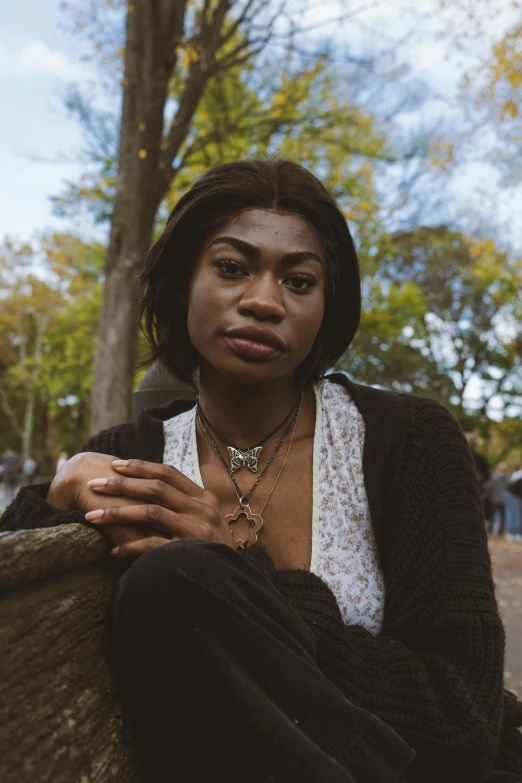 a woman is sitting on a park bench