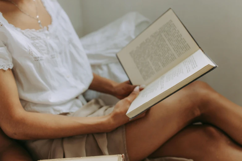 woman reading a book while sitting on the floor