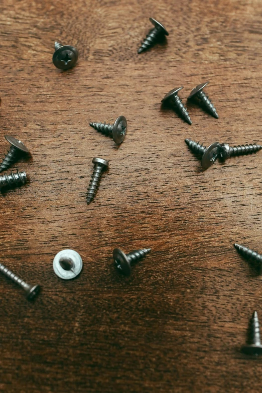 screws and nails scattered on a brown surface